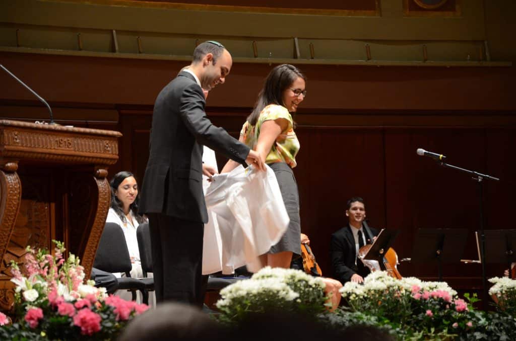 Dr. Sarah Platt receiving her White Coat from her brother, also a physician.